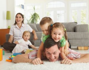 Comfort Family Playing In Living Room Shutterstock 53173996