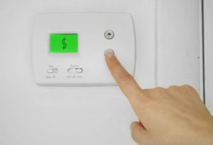 Hand Trying To Adjust Thermostat
